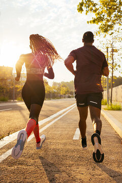 Athletic couple running on road