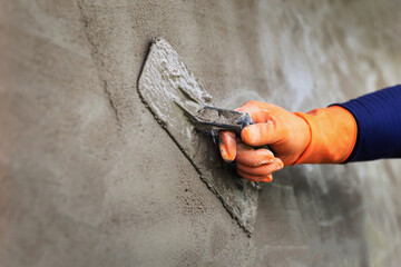 Plastering concrete to create industrial worker wall background with plastering tools - obrazy, fototapety, plakaty
