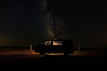Woman inside camper at starry night