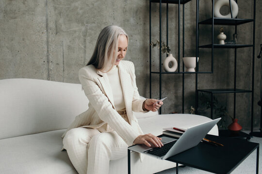 Cheerful senior woman use credit card for shopping