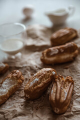 eclairs with cream on a plate. eclairs with whipped cream on the table. cakes with milk on the dining table