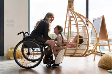 Mother in wheelchair playing with her daughters