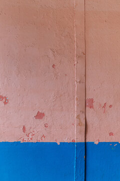 Texture of an old pink and blue wall with a metal strip