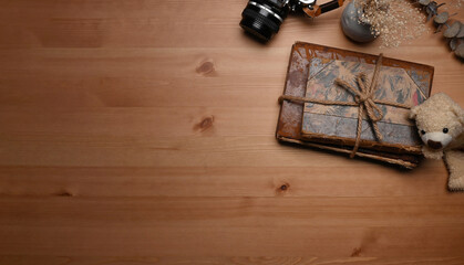 Above view vintage books, camera and teddy bear on wooden table.