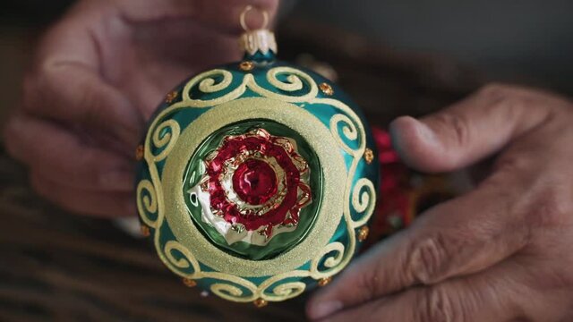 Close-up of woman's hands decorating Christmas tree wist antique retro toy