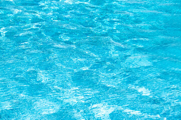 Background of blue water in swimming pool with sun reflection, ripple water wave in pool. Clear water background.