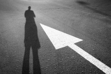 A human shadow next to an arrow