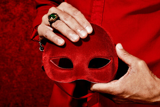man holding a red mask