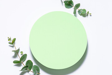 Circle green podiums with eucalyptus leaves on white background top view. Cosmetic branding banner...