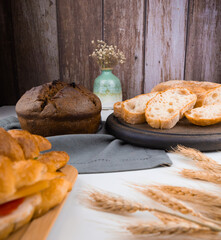 bakery - rustic crusty loaves of bread on wooden background