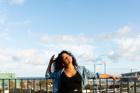 Latin woman relaxing on rooftop 