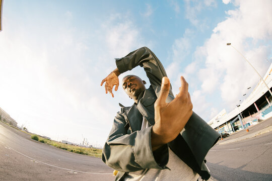 Cool black man moving hands to camera on parking lot
