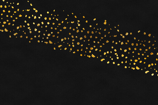 Golden paint from a brush on black matte paper background. 