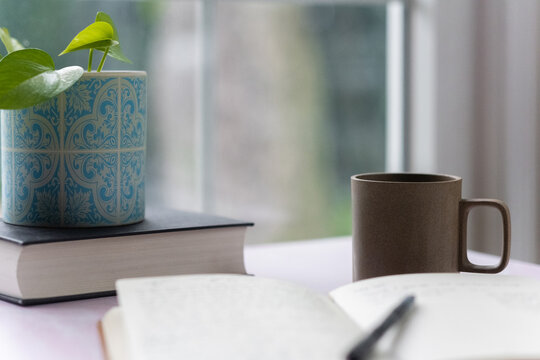 Open notebook and coffee by window