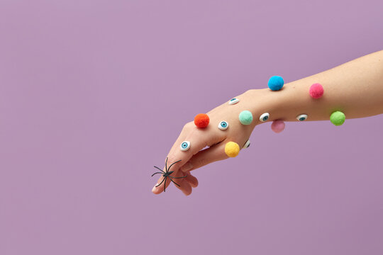 Female hand with colored pompons and eyes