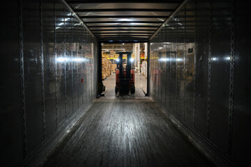 Driver Loading Semi truck at warehouse with forklift 