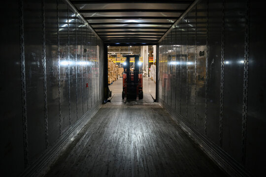 Driver Loading Semi truck at warehouse with forklift 