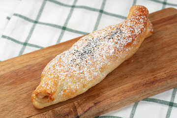Traditional apple strudel on wooden board, close up