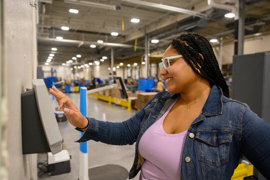 Portrait of factory working checking in on time clock 