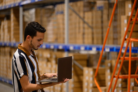Worker with Computer  Checking inventory at Warehouse
