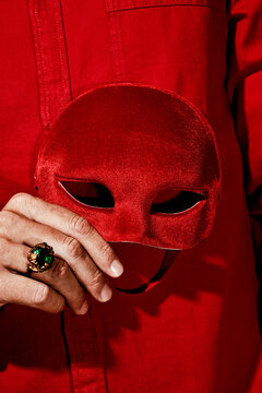 man with a red mask in his hand