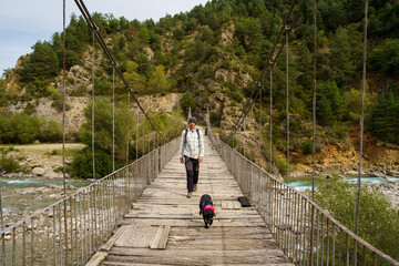 Man and dog crossing bridge