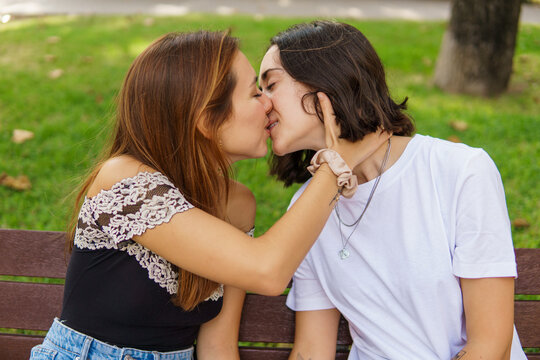 Young women kissing in park