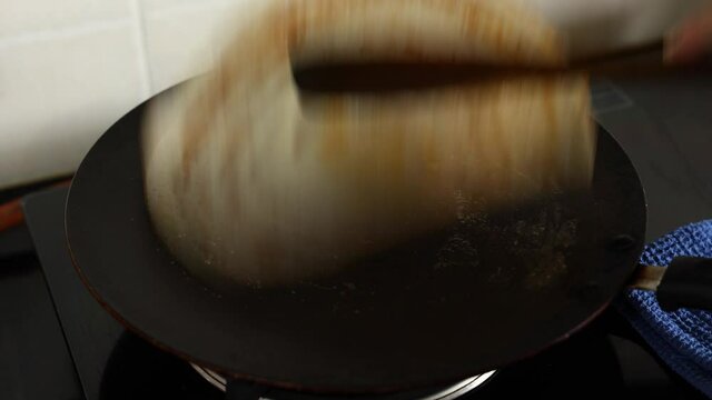 making flipping dosa woman hand cooking breakfast in traditional Indian kitchen 4K video footage fermented crepe made using rice batter lentils ghee popular in South India Kerala Tamil Nadu Sri lanka 