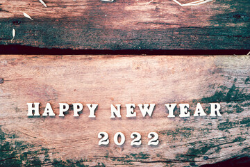 White wood text Happy New Year 2022 on brown wooden plank. Empty space for enter text.