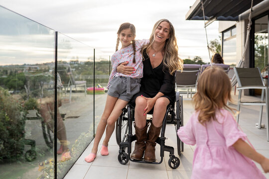 Portrait of mother in wheelchair with her daughters