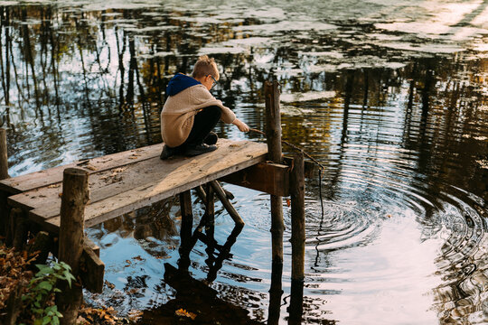 A boy is playing on the pond.