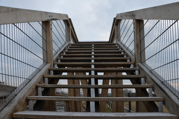The tourist lookout tower slides dangerously down the wooden stairs in winter. hiker in jeans fell from the skin and injured lying on the steps. legs broken with bruises danger of falling