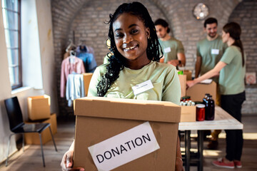Group of volunteers with working in community charity donation center.