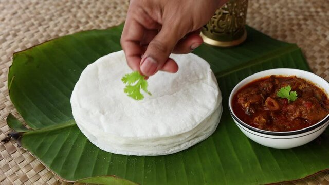 Rice Pathiri pathir flat bread spicy chicken curry woman hand serving traditional South Indian breakfast dish Rice roti 4K video footage Malabar Ramadan Ramzan, Eid festival Kerala India SriLanka