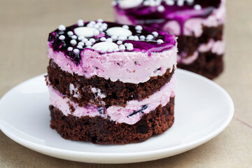 chocolate cake with cream covered with purple berry jam