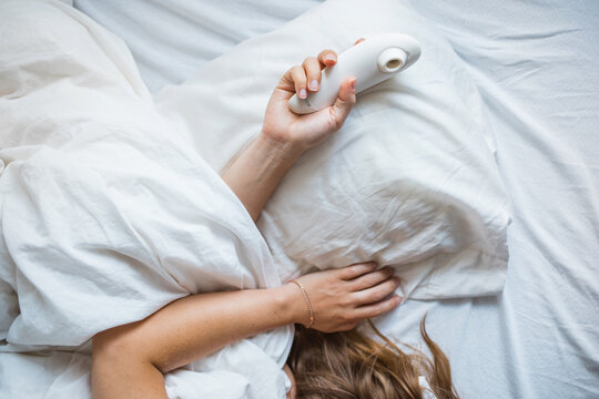 Woman sleeping with sucking vibrator in hand 