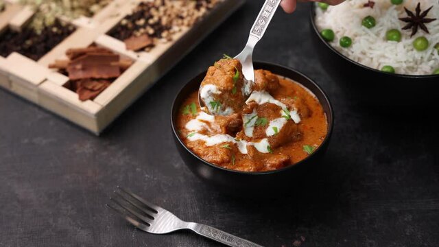 Butter chicken woman hand serving cooking Murgh Makhani curry roast Vindaloo hot spicy dish 4K video footage Dhaba Punjab India North Indian non vegetarian cuisine tikka Masala Chicken curry 