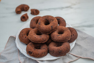 Chocolate glazed donut with chocolate chips on a table