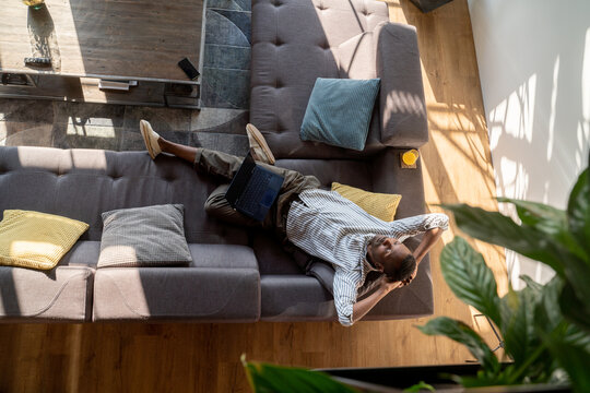 Man Relaxing On The Sofa With Laptop