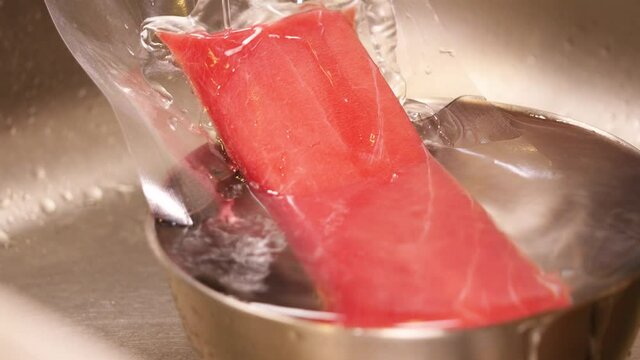 冷凍本マグロの刺身を流水で解凍してる動画。