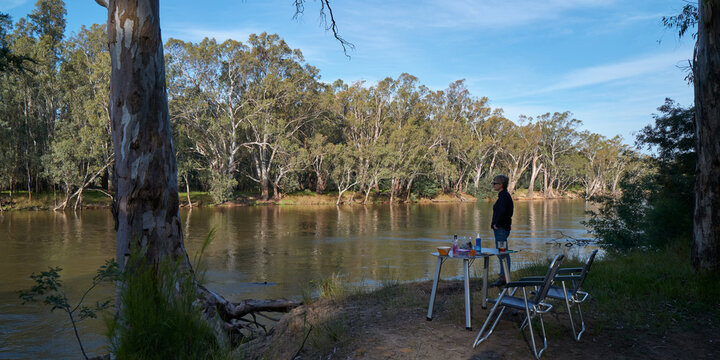 Woman looking out at river at campsite
