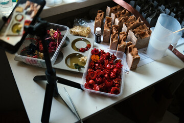 Phone on the tripod filming soap and flowers