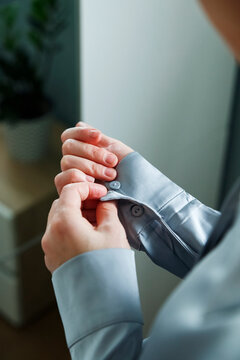 Woman buttoning shirt sleeves