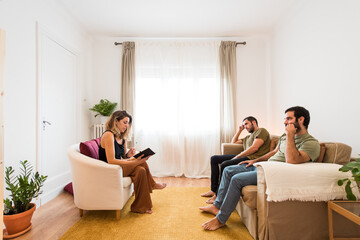 Gay couple carefully listening to their therapist