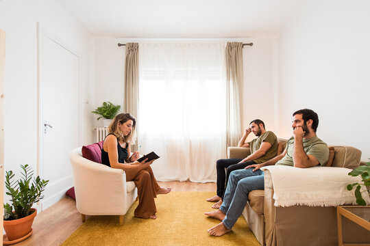 Gay couple carefully listening to their therapist