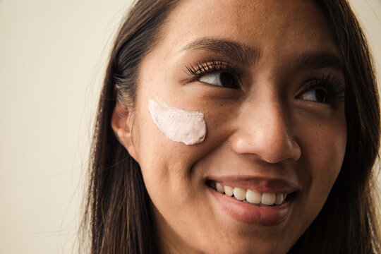 Woman with cream on her cheekbone smiling