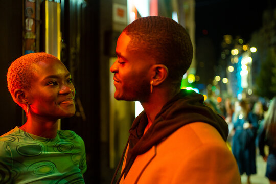 Urban Couple Looking At Each Other In Love At Night.