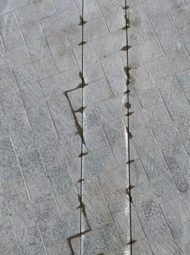 two sharp lines cut through dirty pavement
