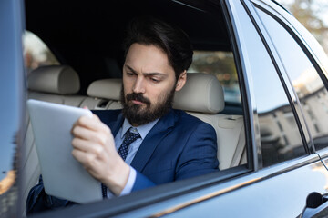 A handsome young businessman is driving in the car