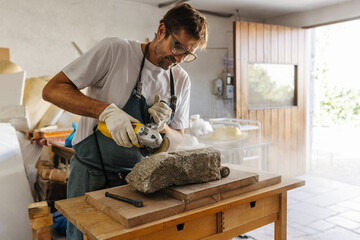 Focused artisan working with stone detail in workshop